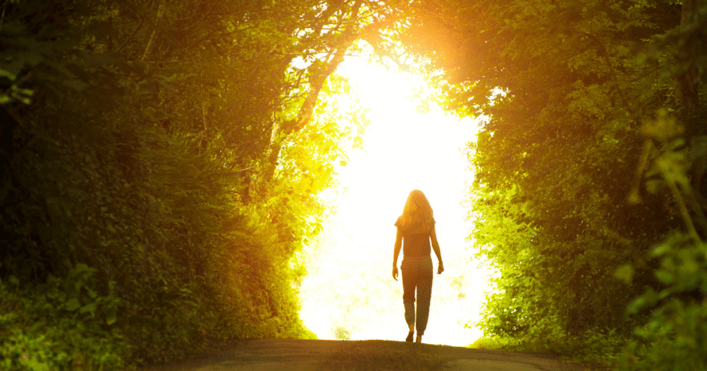 光に向かい進む女性