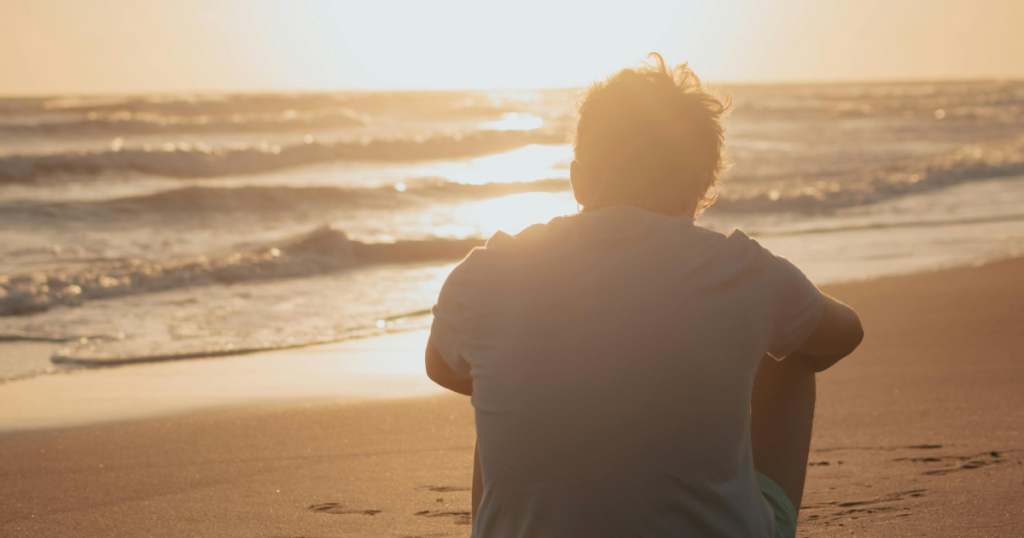 海での寂しげな男性の後ろ姿