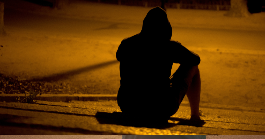 男性の悲しげな座った後ろ姿