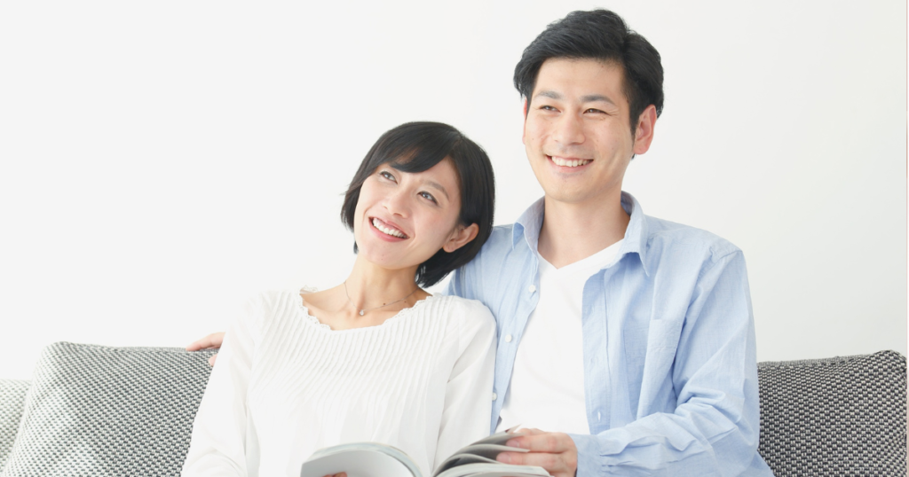 幸せそうな男女がソファーに腰掛け笑っている