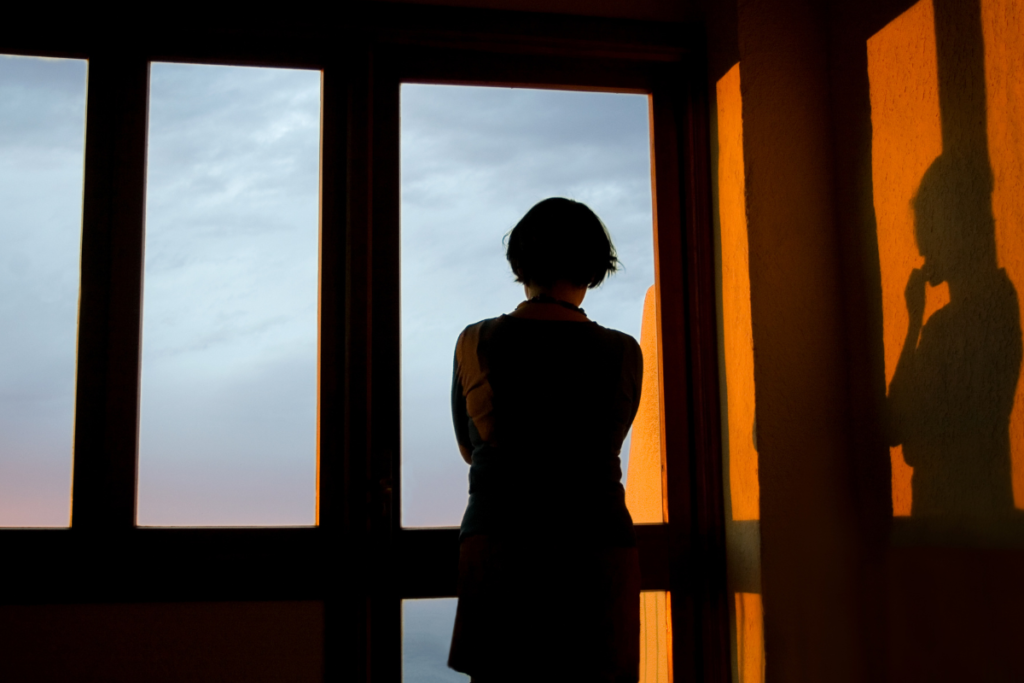 窓の外を見ながら考えている女性後ろ姿