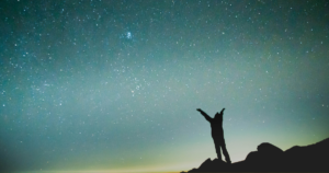 星空に手を広げる男性