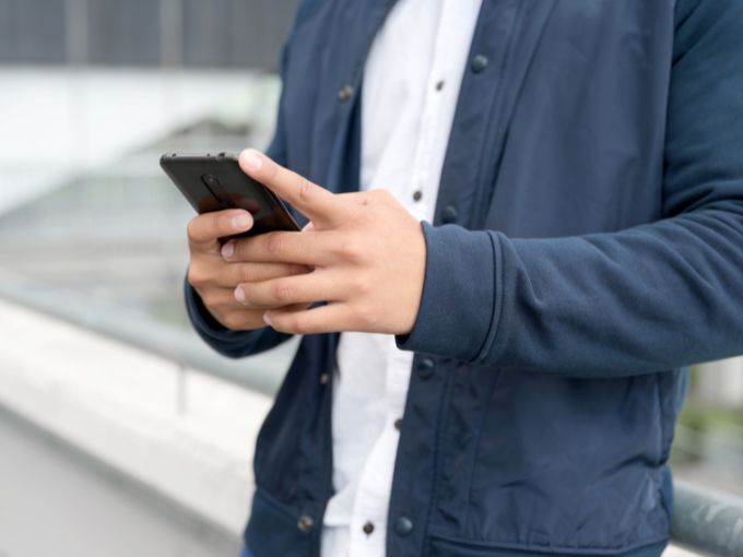 スマホを見ながら躊躇している男性